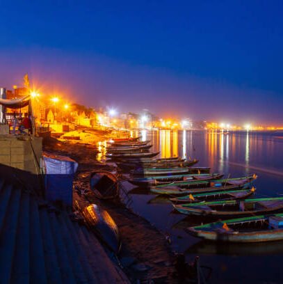 Colorful boats and Ganges river bank in Varanasi city in India at night